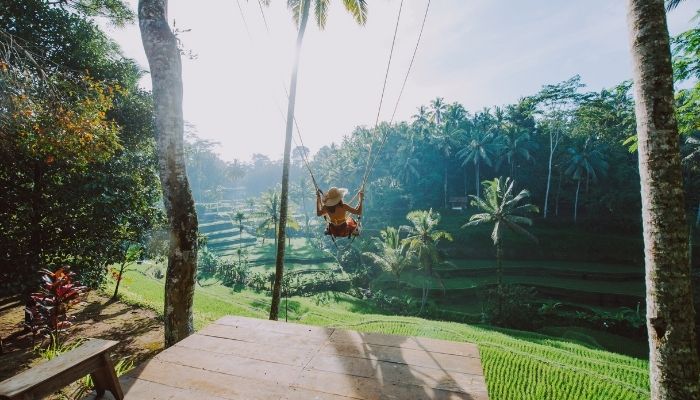 Woman with a hat on a swing in Ubud, Bali, Indonesia