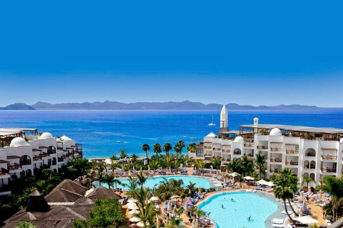 White washed hotel buildings against a cerulean blue sea