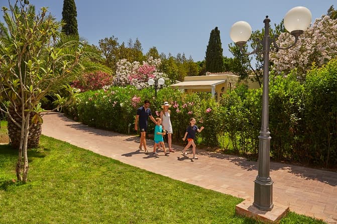 Family walking past Deluxe Bungalow at Hotel Bouganville, Forte Village, Sardinia