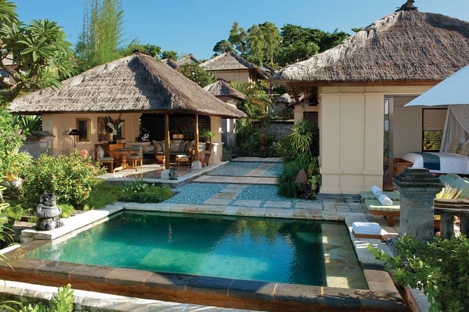Exterior view of a thatched-roof villa with private pool at the Four Seasons Resort at Jimbaran Bay in Bali. 