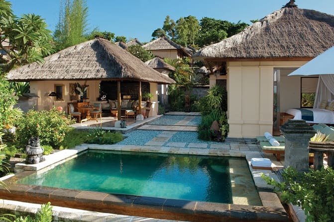 Exterior view of a thatched-roof villa with private pool at the Four Seasons Resort at Jimbaran Bay in Bali.