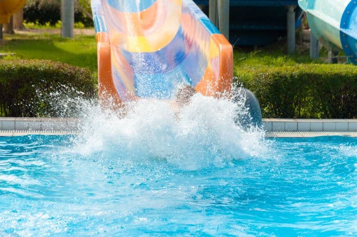 Kid on waterslide splashing into pool